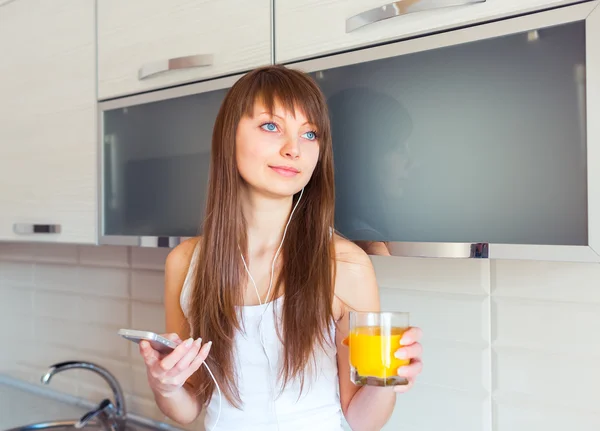 Giovane donna in cucina ad ascoltare musica — Foto Stock