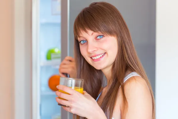 Jovem menina morena caucasiana com um copo de suco no gatinho — Fotografia de Stock