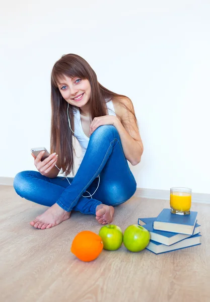 Retrato de uma jovem com fones de ouvido e maçã verde ouvir — Fotografia de Stock