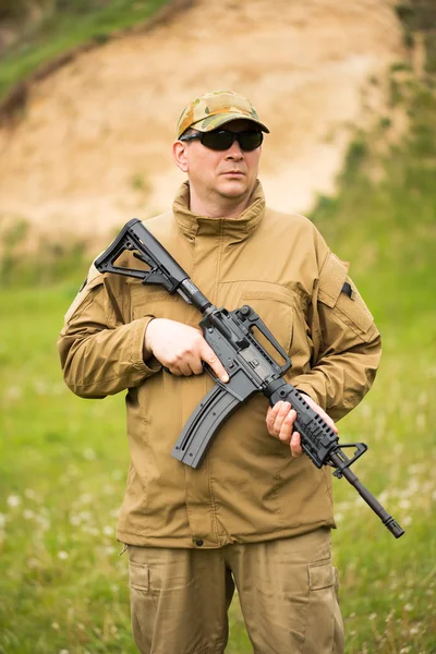 Soldato vestito con un camuffamento con una pistola — Foto Stock