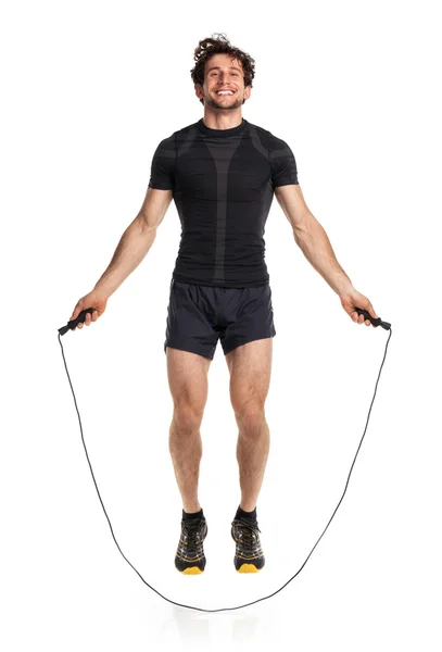 Athletic attractive man jumping on a rope on the white — Stock Photo, Image