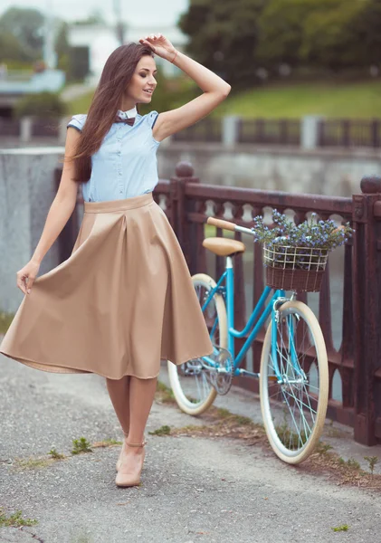 Joven mujer hermosa, elegantemente vestida con bicicleta — Foto de Stock