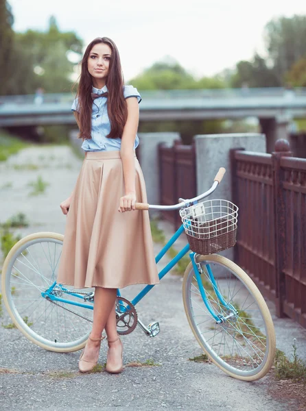 Giovane donna bella, elegantemente vestita con bicicletta — Foto Stock