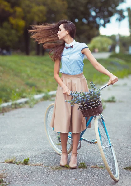 Молодая красивая, элегантно одетая женщина с велосипедом — стоковое фото