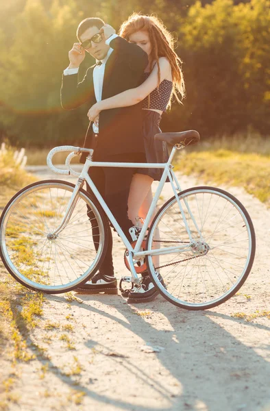 Young stylish guy with girl and the bicycle outdoors — Stock Photo, Image