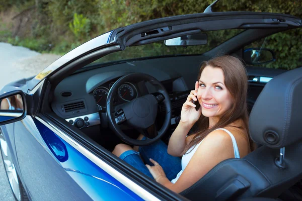 Leende kvinna prata telefon i en cabriolet bil — Stockfoto