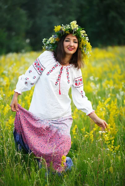 Молодая улыбающаяся девушка в украинском костюме с венком на шее — стоковое фото