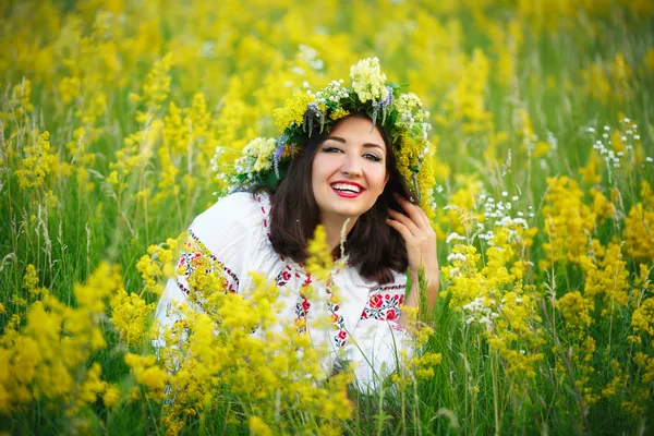 Młoda dziewczyna uśmiechający się w strój ukraiński z wieniec na jego hea — Zdjęcie stockowe