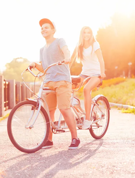 Happy couple riding a bicycle in the city street — Stock Photo, Image