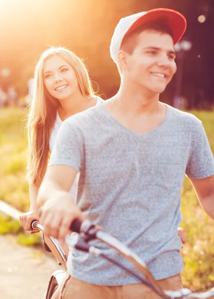 Pasangan bahagia mengendarai sepeda di jalan kota — Stok Foto