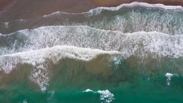 Вид с воздуха на побережье Средиземного моря, волны достигают пустынного песчаного пляжа. Отдых и туризм на Крите, Греция. — стоковое видео