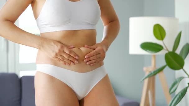 Femme comprimant la peau sur le ventre et les côtés vérifiant la cellulite et l'excès de graisse sous-cutanée — Video