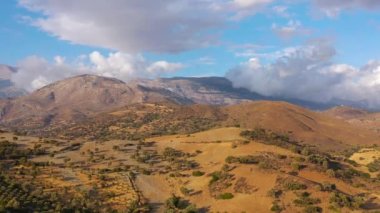 Yunanistan 'daki Girit adasının havadan görünüşü. Dağ manzarası, zeytin ağaçları, gün batımında bulutlu gökyüzü..