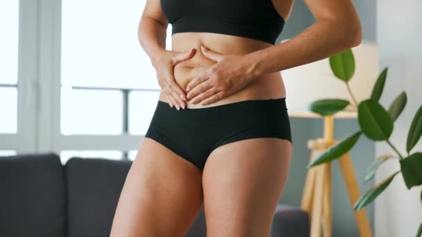 Mulher comprimindo a pele em seu estômago e lados verificando se há celulite e excesso de gordura subcutânea — Vídeo de Stock