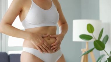 Kadın karnına ve yanlarına baskı yapıyor. Selülit ve deri altında yağ var mı diye kontrol ediyor.