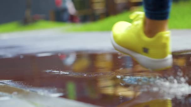 Femme sportive faisant du jogging à l'extérieur, entrant dans la flaque d'eau. Un seul coureur court sous la pluie, faisant des éclaboussures. Mouvement lent — Video