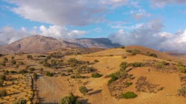 Yunanistan 'daki Girit adasının havadan görünüşü. Dağ manzarası, zeytin ağaçları, gün batımında bulutlu gökyüzü..