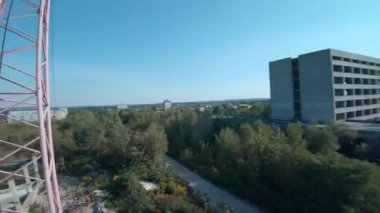FPV insansız hava aracı terk edilmiş sanayi binaları ve bir kazıcının etrafında sorunsuzca uçuyor..