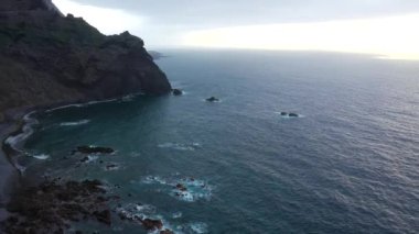 Tenerife adasının kayalık kıyısında uçuş. Deniz dalgalarının kıyıya ulaşan hava aracı görüntüleri.