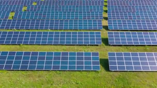 Survolez un champ de panneaux solaires lors d'une journée ensoleillée d'été. Innovation écologique. — Video