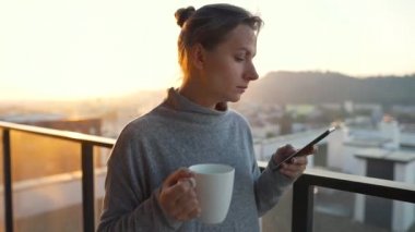 Kadın güne bir fincan çay ya da kahveyle başlıyor ve şafak vakti balkondaki akıllı telefonundaki e-postaları kontrol ediyor..
