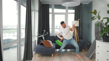 Adam temizlik yapıyor ve kendini rock yıldızı olarak hayal ediyor. Süpürgeyi gitar gibi çalıyor. Yavaş çekim