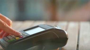 NFC kredi kartı ödemesi. NFC teknolojisiyle kredi kartıyla ödeme yapan bir kadın. Kablosuz para transferi. Kablosuz ödeme