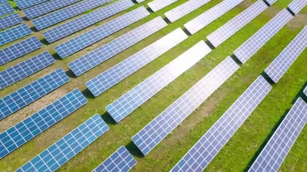 Survolez un champ de panneaux solaires lors d'une journée ensoleillée d'été. Innovation écologique. — Video