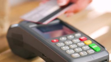 NFC kredi kartı ödemesi. NFC teknolojisiyle kredi kartıyla ödeme yapan bir kadın. Kablosuz para transferi. Kablosuz ödeme