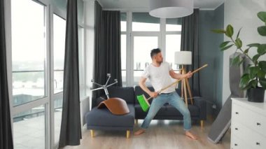 Adam temizlik yapıyor ve kendini rock yıldızı olarak hayal ediyor. Süpürgeyi gitar gibi çalıyor..
