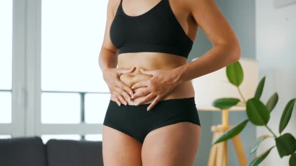 Kvinna komprimera huden på magen och sidorna kontroll för celluliter och överskott subkutant fett — Stockvideo
