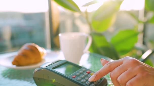 Pago sin contacto con smartphone. Concepto de pago inalámbrico. Primer plano, mujer que utiliza la tecnología NFC billetera sin efectivo smartphone para pagar la orden en la terminal bancaria en un café. — Vídeo de stock