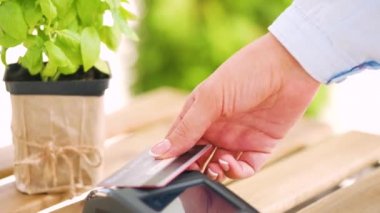 NFC kredi kartı ödemesi. NFC teknolojisiyle kredi kartıyla ödeme yapan bir kadın. Kablosuz para transferi. Kablosuz ödeme