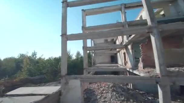 FPV drone flies quickly and maneuverable among abandoned industrial buildings and an excavator. — Wideo stockowe