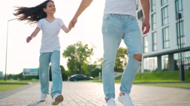 Baba ve kızı gün batımında kendi bölgelerinde dolaşırlar. Çocuk babasının elini tutuyor. Yavaş çekim
