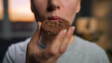 Kadın çikolatalı kurabiye yiyor.