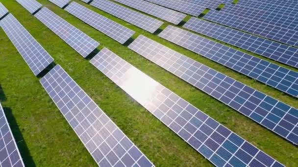 Survolez un champ de panneaux solaires lors d'une journée ensoleillée d'été. Innovation écologique. — Video