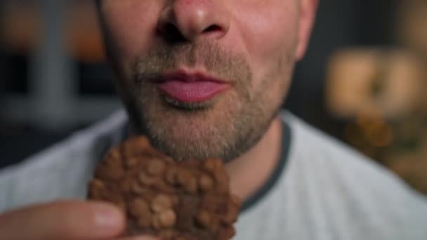 Ο άνθρωπος τρώει μπισκότα σοκολάτας. — Αρχείο Βίντεο