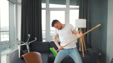 Adam temizlik yapıyor ve kendini rock yıldızı olarak hayal ediyor. Süpürgeyi gitar gibi çalıyor. Yavaş çekim
