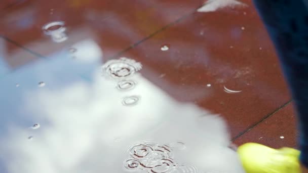 女运动员在户外慢跑，踏入水坑。一个跑步者在雨中奔跑，造成飞溅。慢动作 — 图库视频影像