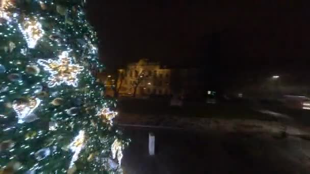 Χριστουγεννιάτικο δέντρο της πόλης. Γιορτινά διακοσμημένο πράσινο χριστουγεννιάτικο δέντρο με παιχνίδια, χρυσές μπάλες, ηλεκτρικές μπλε αστραφτερές γιρλάντες. Γρήγορη, ευέλικτη πτήση γύρω από το χριστουγεννιάτικο δέντρο σε FPV drone. — Αρχείο Βίντεο