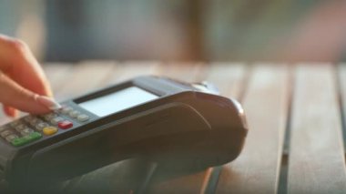 NFC kredi kartı ödemesi. NFC teknolojisiyle kredi kartıyla ödeme yapan bir kadın. Kablosuz para transferi. Kablosuz ödeme