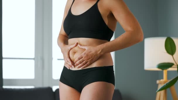 Donna che comprime la pelle dello stomaco e dei fianchi controllando la cellulite e il grasso sottocutaneo in eccesso — Video Stock
