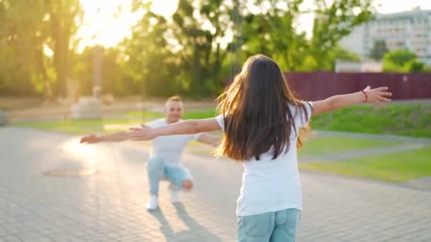 Kızı babasına koşuyor ve ona sarılıyor. Baba çocuğu kollarına alır. Yavaş çekim — Stok video