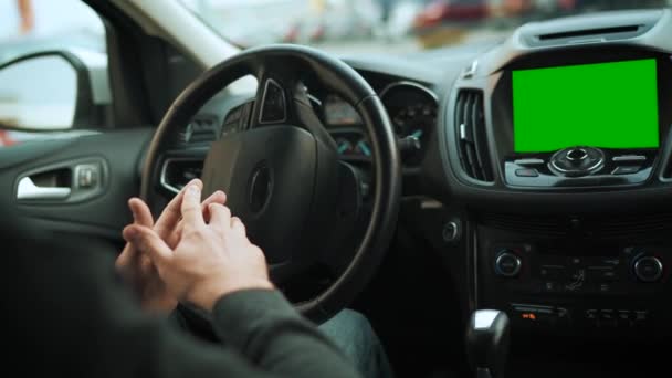 Muž jedoucí v inovativním automatizovaném autě s autopilotem pro parkování na parkovišti. Autosalon se zelenou maketou. Zadní pohled zpoza ramene řidiče — Stock video