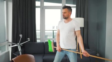 Adam temizlik yapıyor ve kendini rock yıldızı olarak hayal ediyor. Süpürgeyi gitar gibi çalıyor..