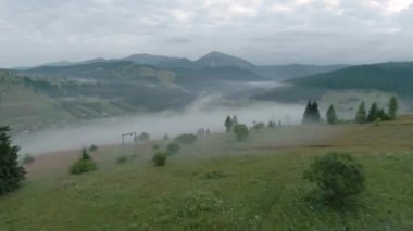 Sabah sisli bir şekilde yamaçtan uçacağız. FPV insansız hava aracı ile çekildi. Orman ve dağlar arka planda görünür..