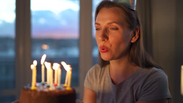 Feliz mujer emocionada haciendo deseos preciados y soplando velas en el pastel de vacaciones, celebrando cumpleaños en casa, cámara lenta — Vídeos de Stock