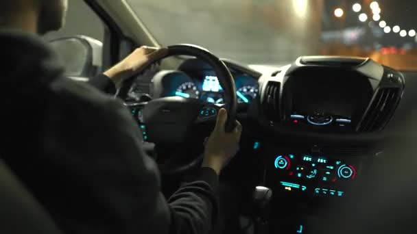 男の夜の街の通りを車で運転。車の後部座席からの眺め. — ストック動画