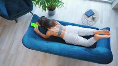 Kablosuz kulaklık takan, müzik dinleyen, mobil uygulamalar kullanan ya da sosyal ağlarda akıllı telefondan iletişim kuran yeşil model ekranlı bir kadın.